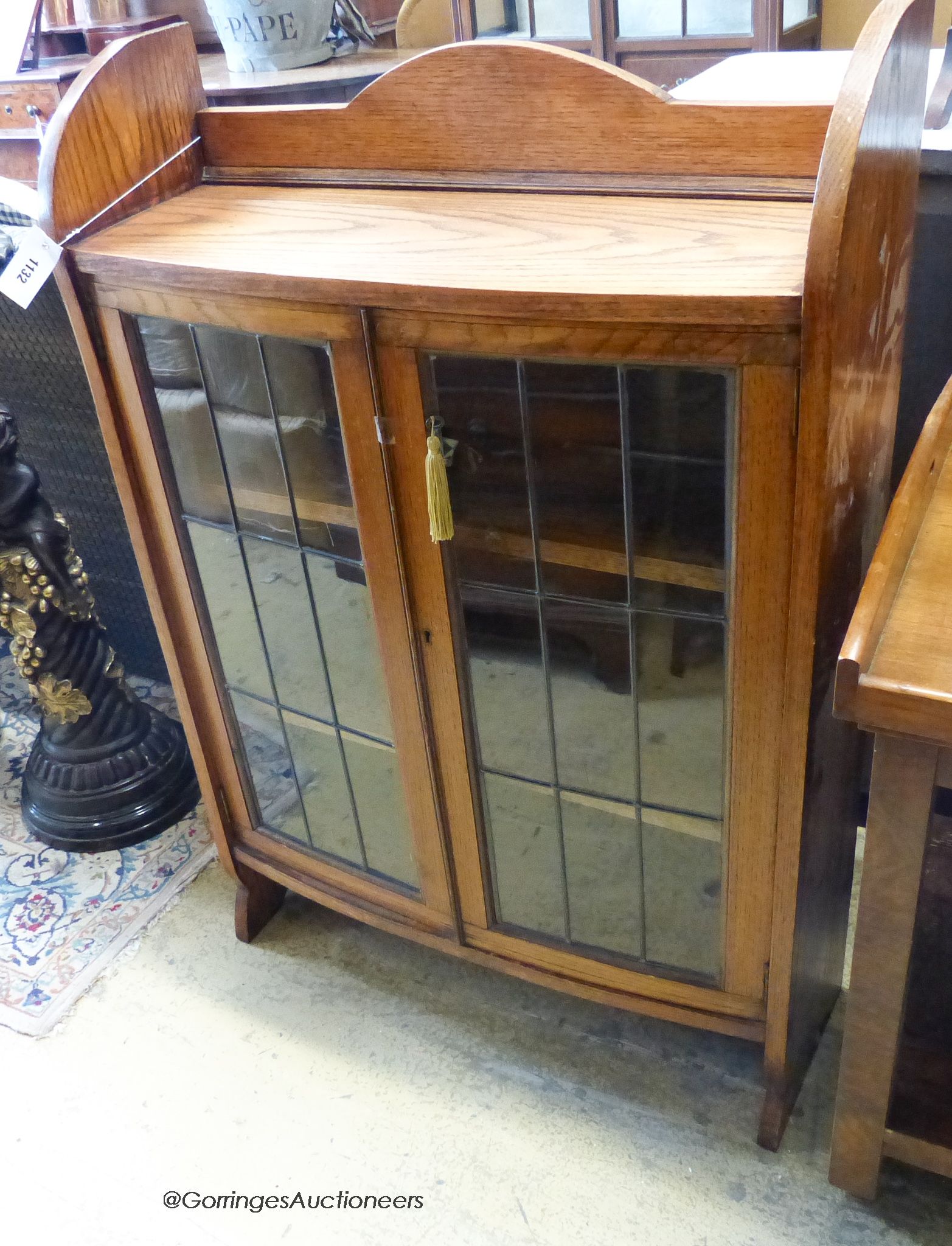 A 1920's leaded glazed bowfront oak bookcase. W-73, D-25, H-108cm.